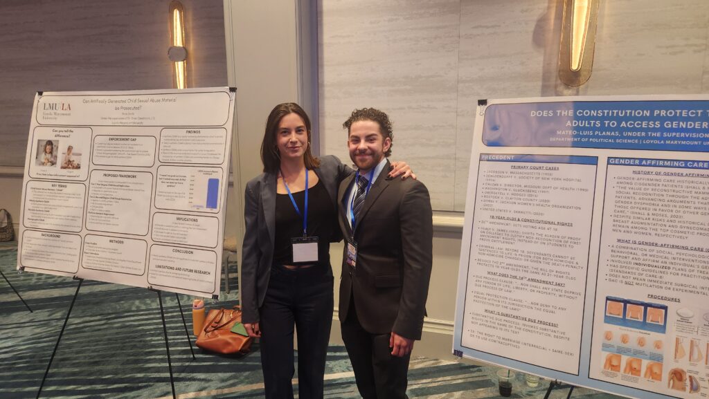 Students presenting research posters in business casual attire.