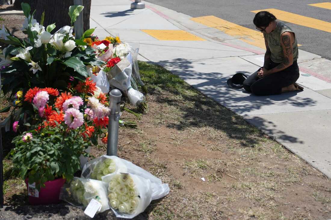 Nicole Witherow prays beside flowers placed outside the Islamic Center of San Diego on May 19.