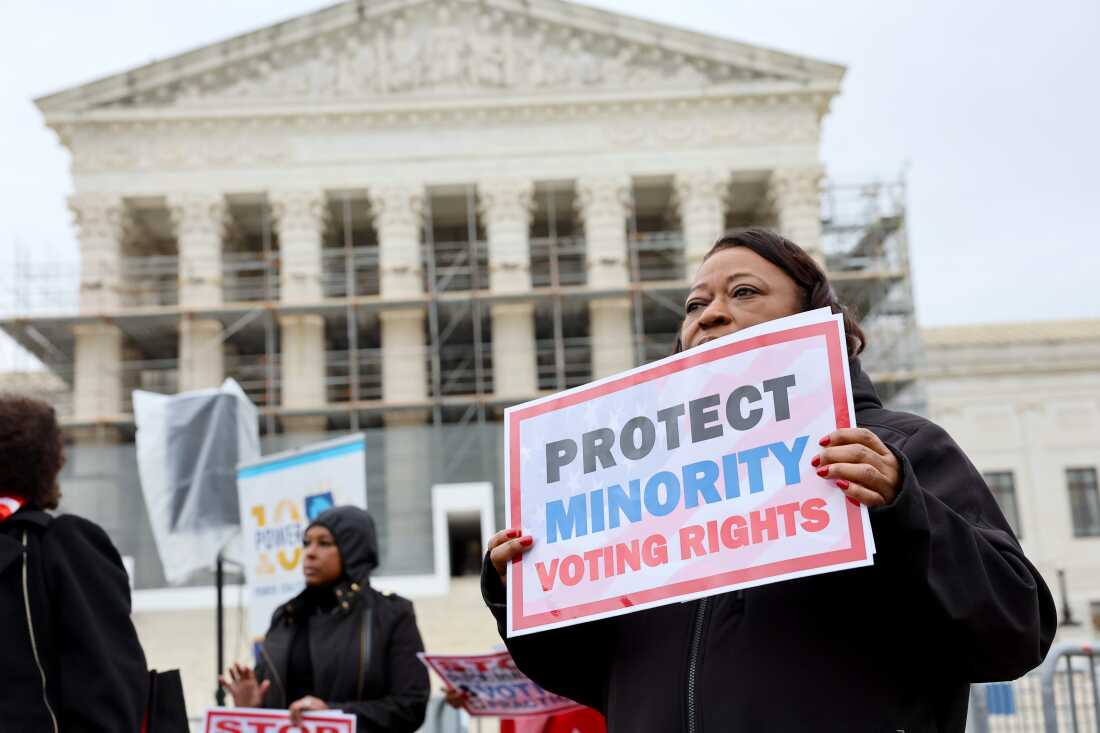 A demonstrator holds a sign saying &ldquo;PROTECT MINORITY VOTING RIGHTS&rdquo; at a March 2025 rally outside the U.S. Supreme Court in Washington, D.C.