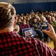 Photograph of the back of Graham Platner's head in front of a crowd of supporters in a school gym.