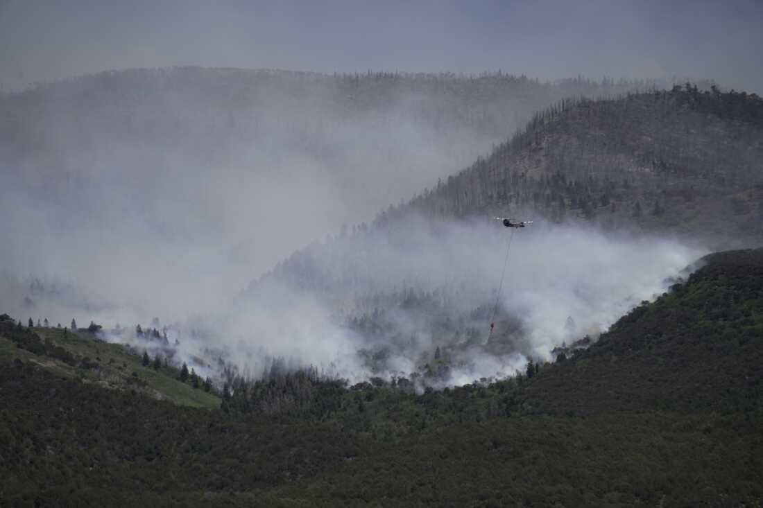 A helicopter drops water on the Cottonwood Fire in Beaver, Utah, on Saturday, June 27, 2026.