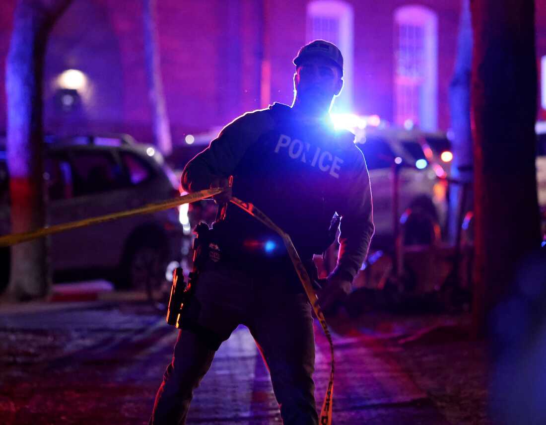 A police officer hangs yellow crime tape at Brown University in Providence, R.I., on Dec. 13, 2025, during the investigation of a shooting.
