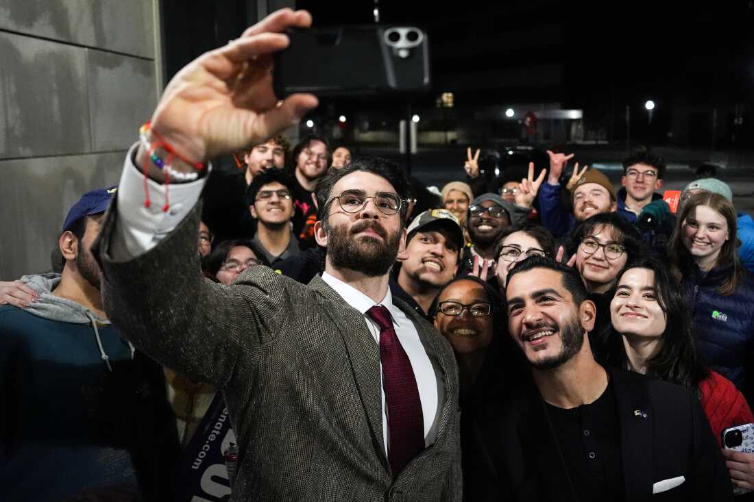 Streamer Hasan Piker, left, and Abdul El-Sayed, a progressive candidate in the Democratic primary for U.S. Senate in Michigan, center right, take a selfie with young fans following a campaign event on April 7, 2026, at the University of Michigan in Ann Arbor.