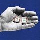 An illustration of a black-and-white hand holding a miniature dollar bill over a blue background.